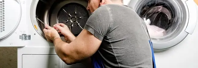 Dryer repair technician fixing a clothes dryer drum in Orange, CA