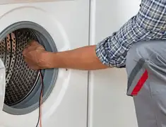 Dryer repair technician diagnosing and servicing a clothes dryer in Orange, CA