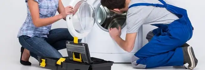 Washer repair technician inspecting a front-load washing machine with tools in Orange, CA