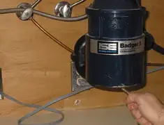 Garbage disposal repair technician tightening the mounting ring under a sink in Orange, CA