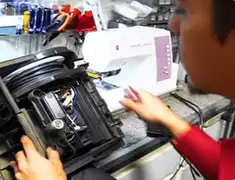 Vacuum repair technician servicing internal components on a workbench in Orange, CA