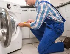 Washing machine repair technician servicing a front-load washer in Orange, CA