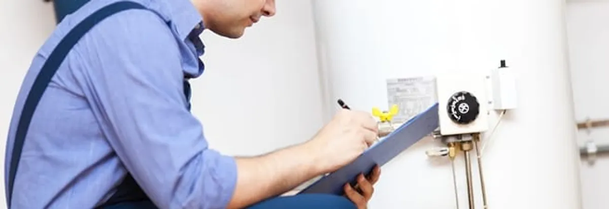 Water heater repair technician inspecting the unit and recording service notes in Orange, CA