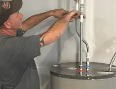 Water heater repair technician tightening supply line connections in Orange, CA